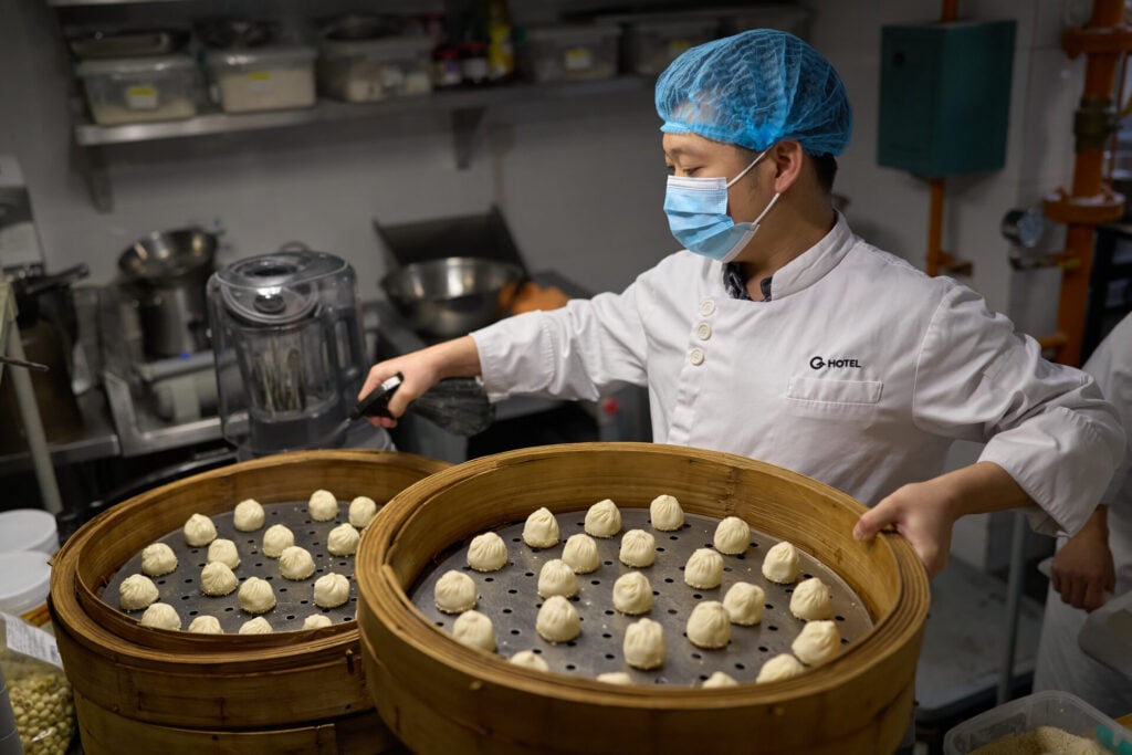 Man putting dumplings on plates