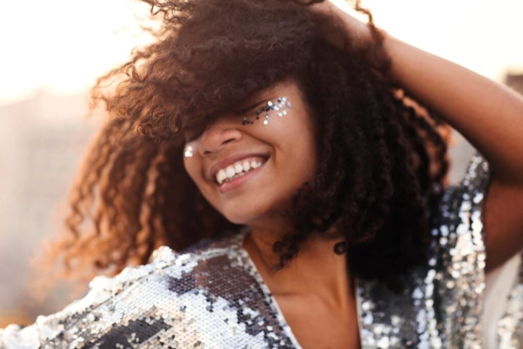 festival goer dancing with glitter on her face