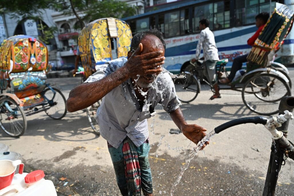 a man with his hand over his face and water coming out of his mouth