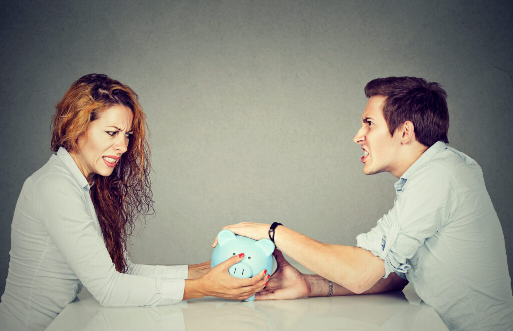 couple fighting over a piggy bank 