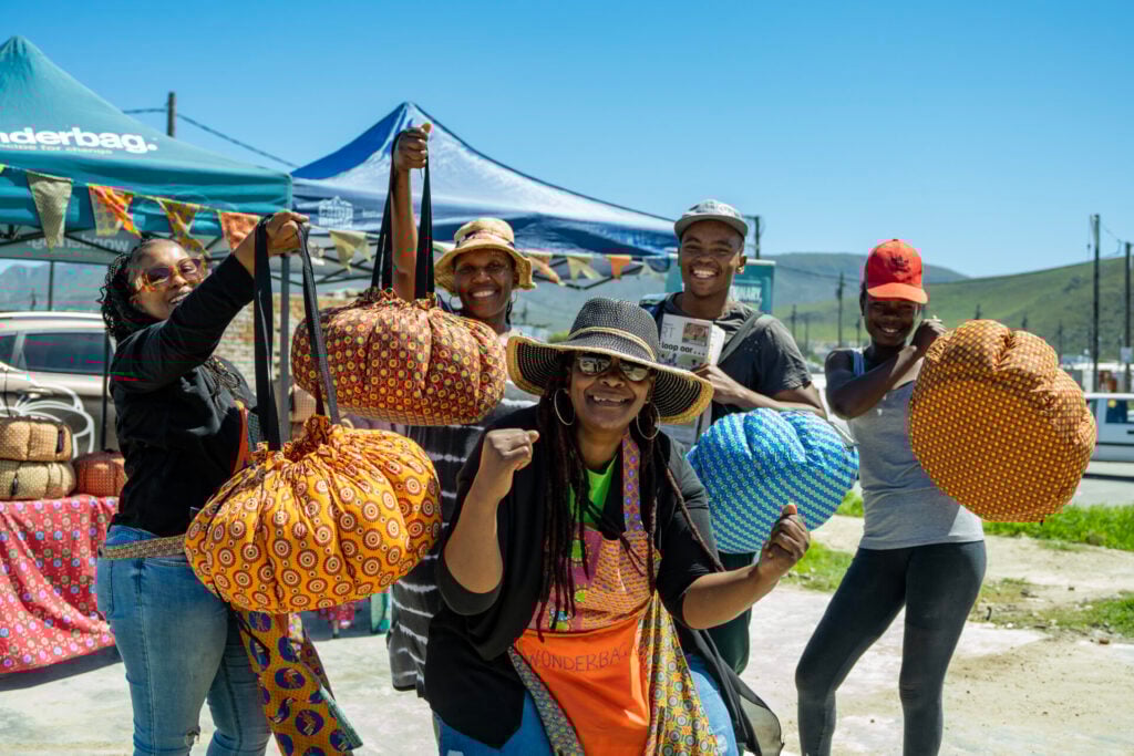 % people holding the wonderbag and smiling