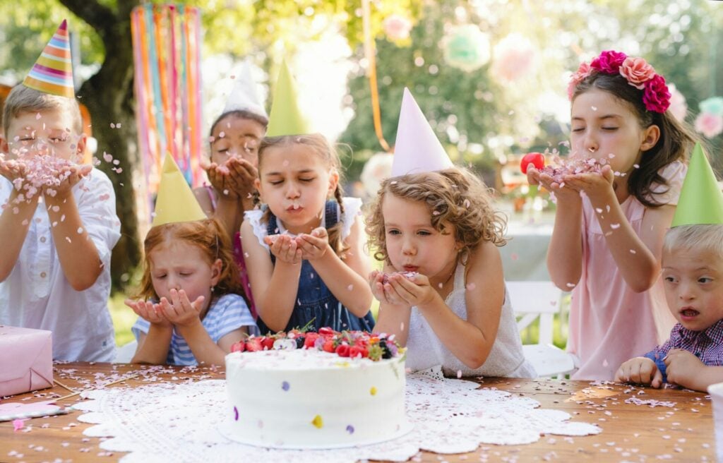 Blowing activities can include blowing confetti like the children seen in this picture at a party