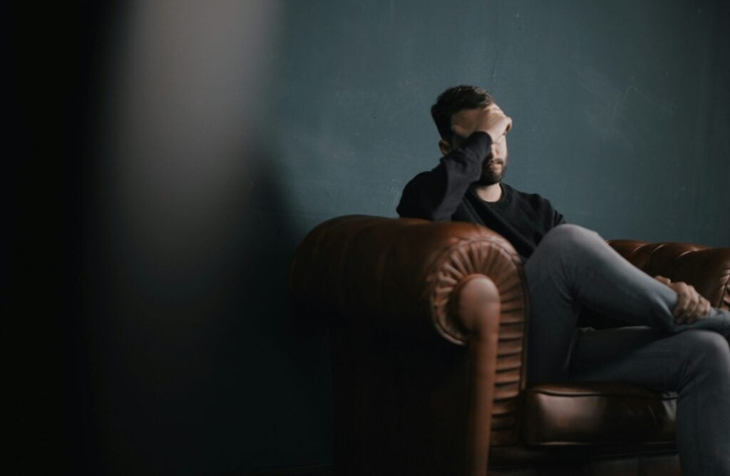 man depressed on sofa