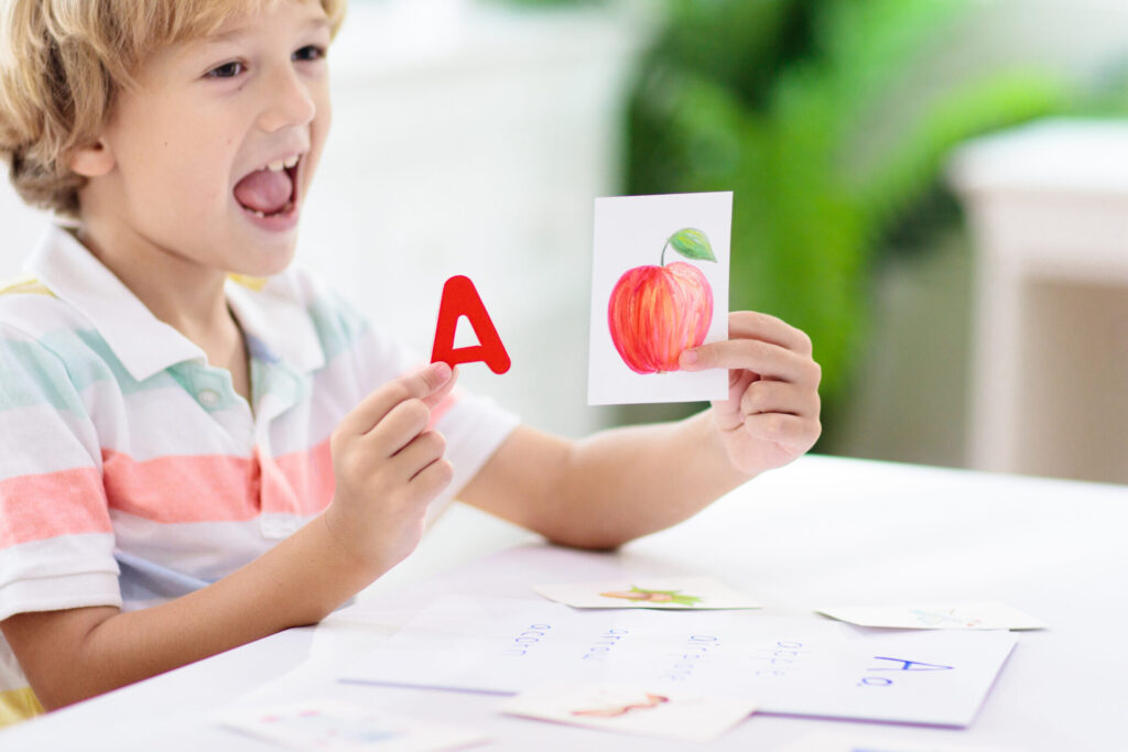 a child holding a piece of paper with a letter