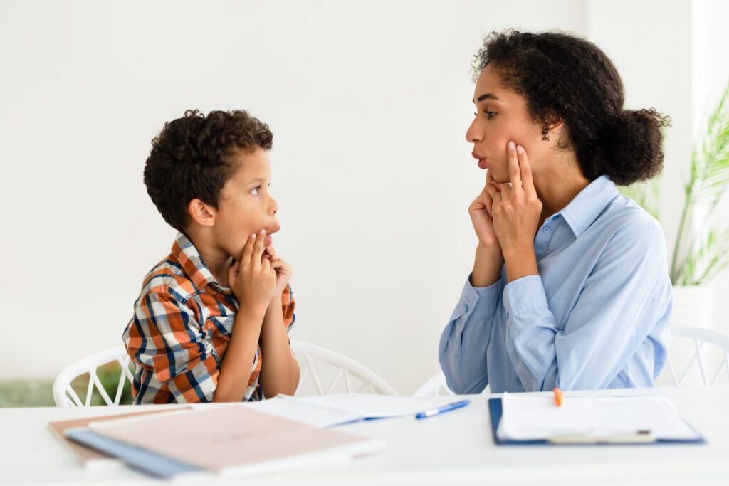 mother performing speech therapy exercises with her son