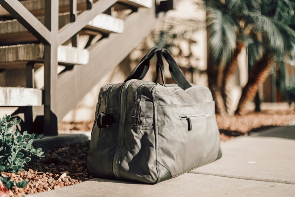 overnight bag on pavement next to palm tree