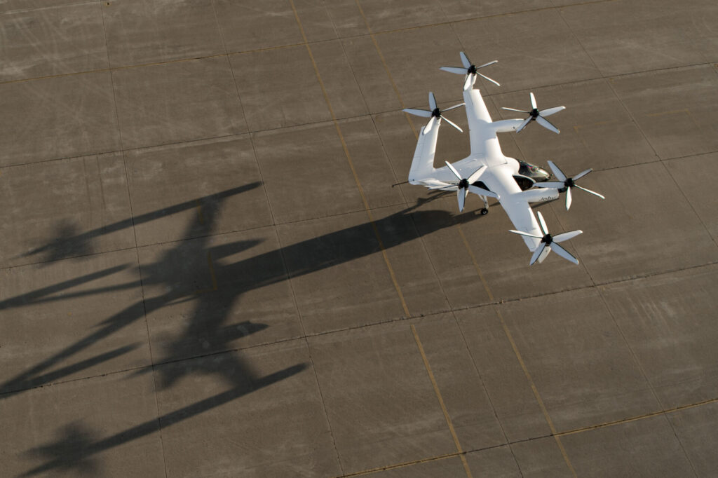 a white eVTOL Joby plane with propellers on a runway