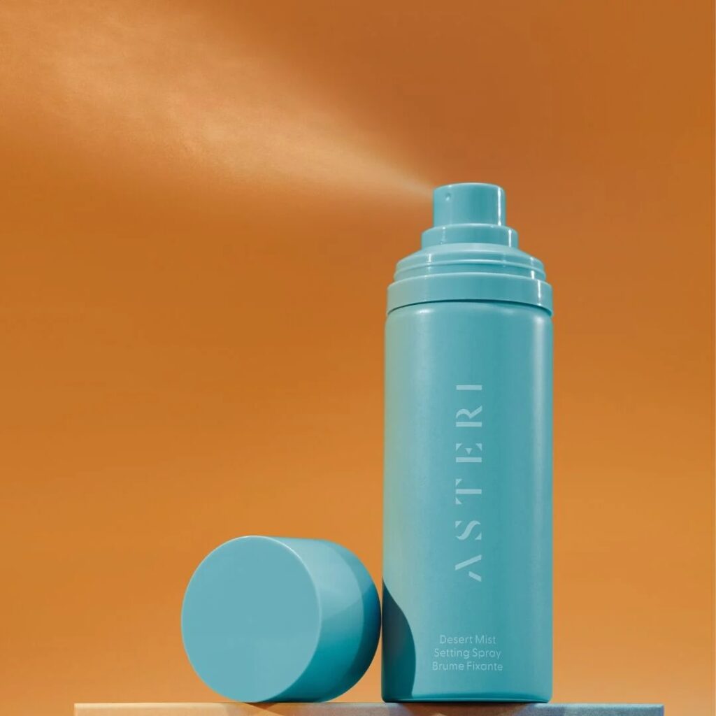 Aqua spray bottle on orange background