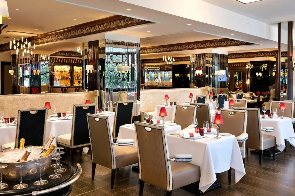 a restaurant with tables and chairs at Hôtel Barrière Le Majestic