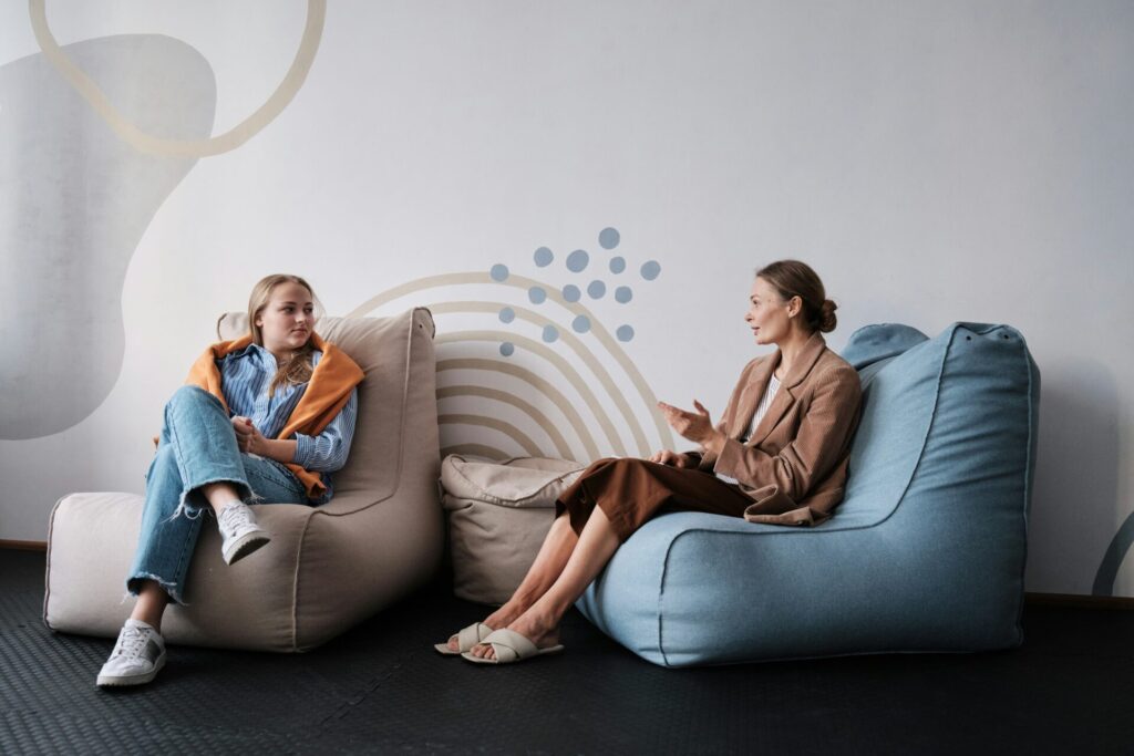 two women sitting in bean bags - one is older than the other suggesting a school psychologist and a student