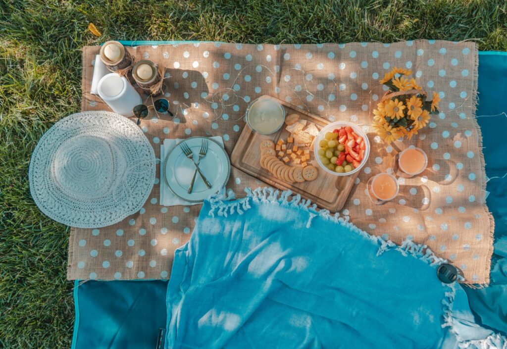a picnic blanket with food and drinks on it