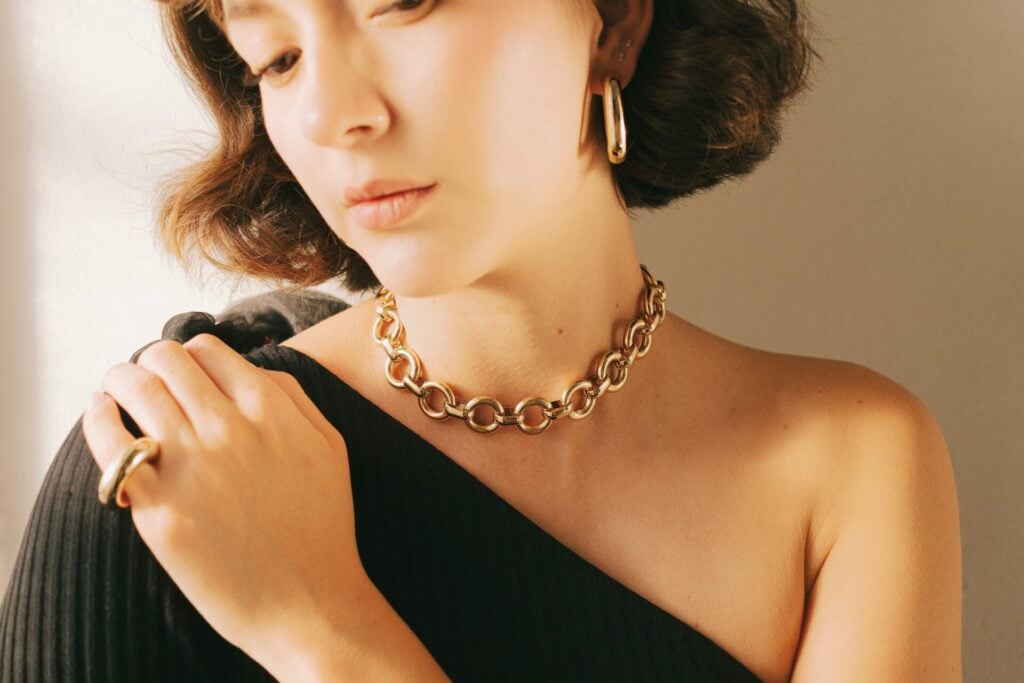a woman wearing a gold necklace