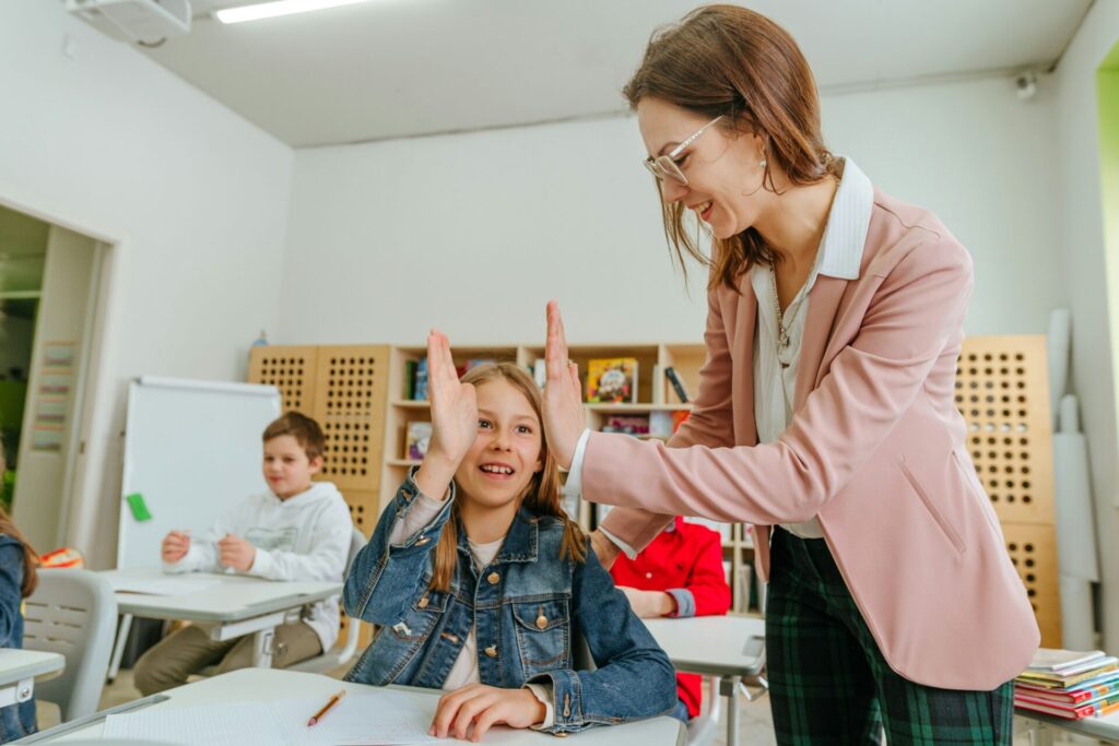 School psychologist high five's a child in the classroom