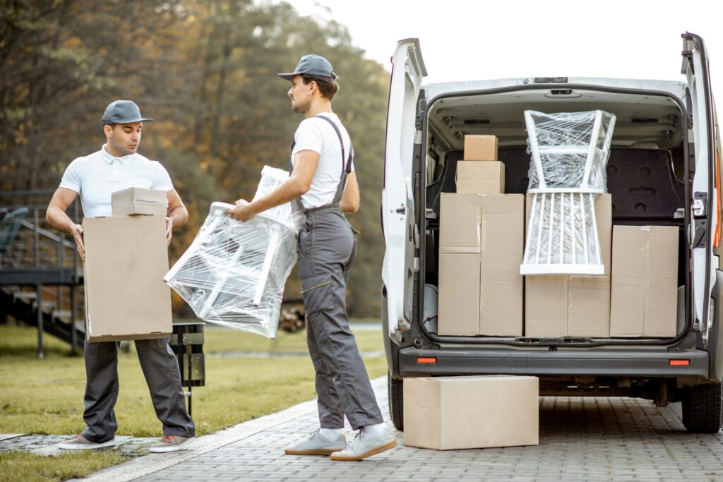 two men loading boxes into a van