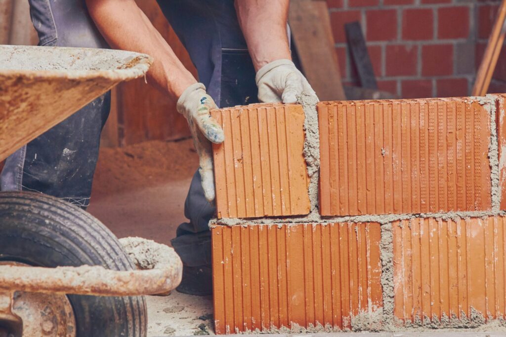 a man placing a brick on a wall