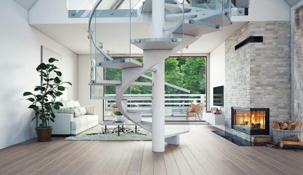 a spiral staircase in a room with a fireplace and large patio doors looking out onto tree lined garden 