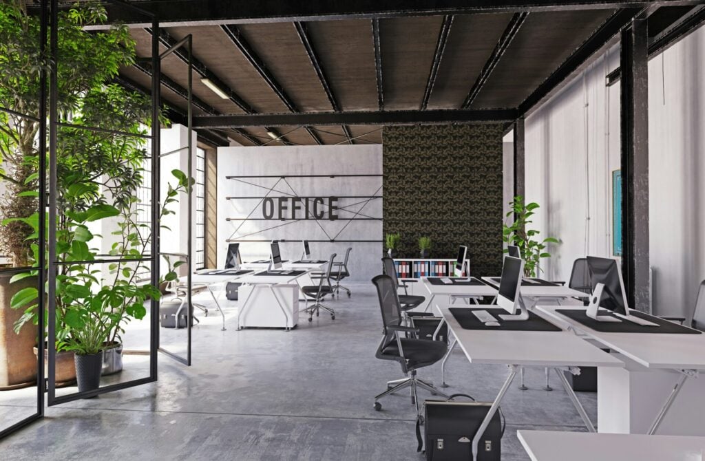 an office with white tables and chairs and green foliage 