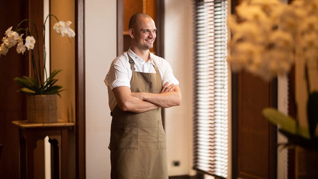 Jimmy Ophorst, head chef of PRU in Phuket and Thailand’s first Green Star awardee, stands near a window in his apron