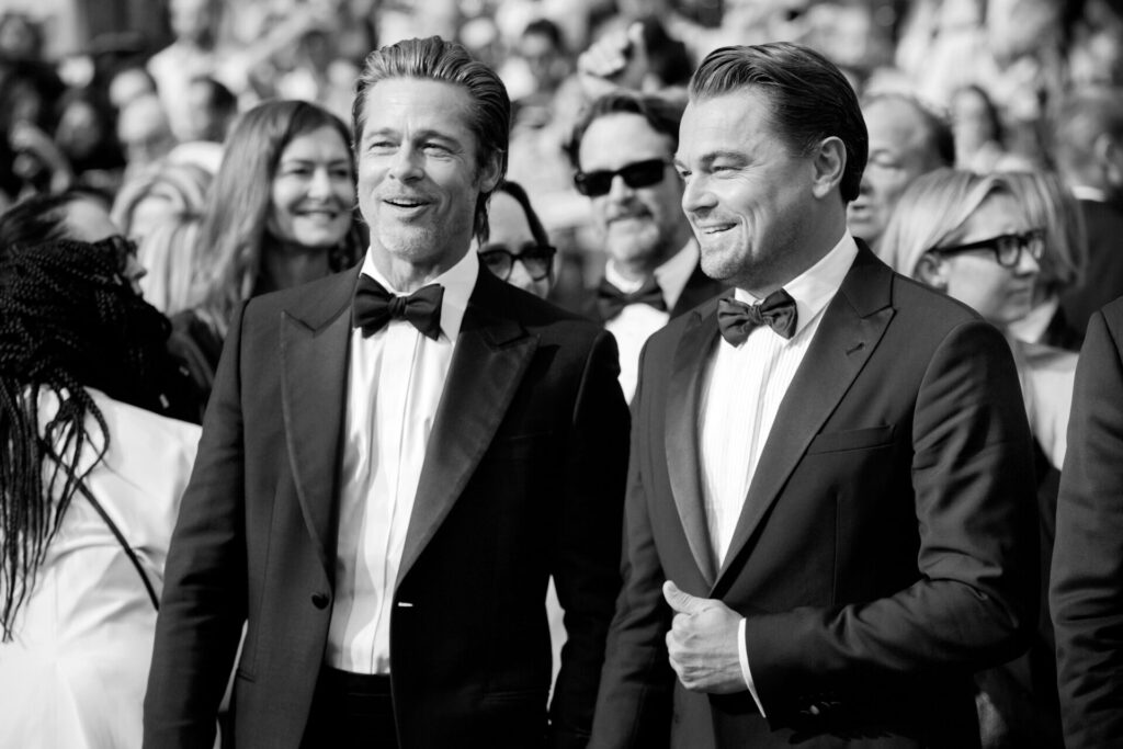 Leonardo DiCaprio and Brad Pitt in suits smiling