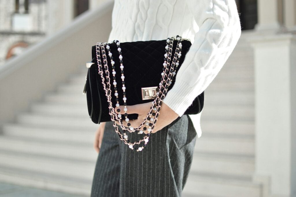 a person holding a designer handbag showcasing the ease of high-low styling 