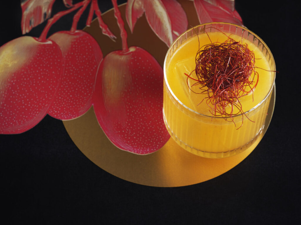 a cocktail with orange liquid and a red thread on top - a new nature inspired drink at GǑNG in London