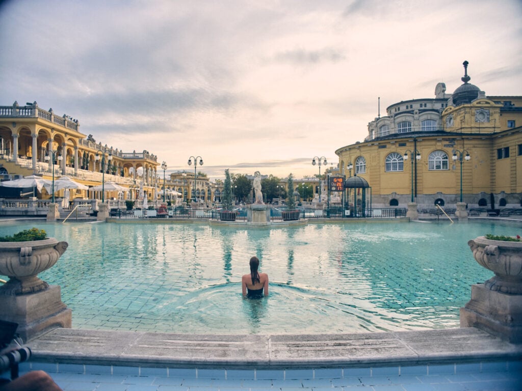 Person swimming in serene historic pool