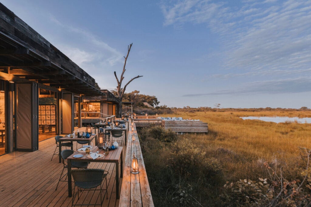 Scenic outdoor dining by the water at a wilderness destination camp in Botswana 