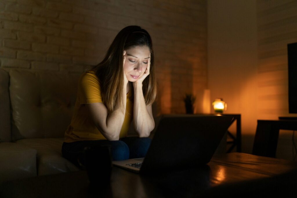 Person sitting alone, looking distressed.