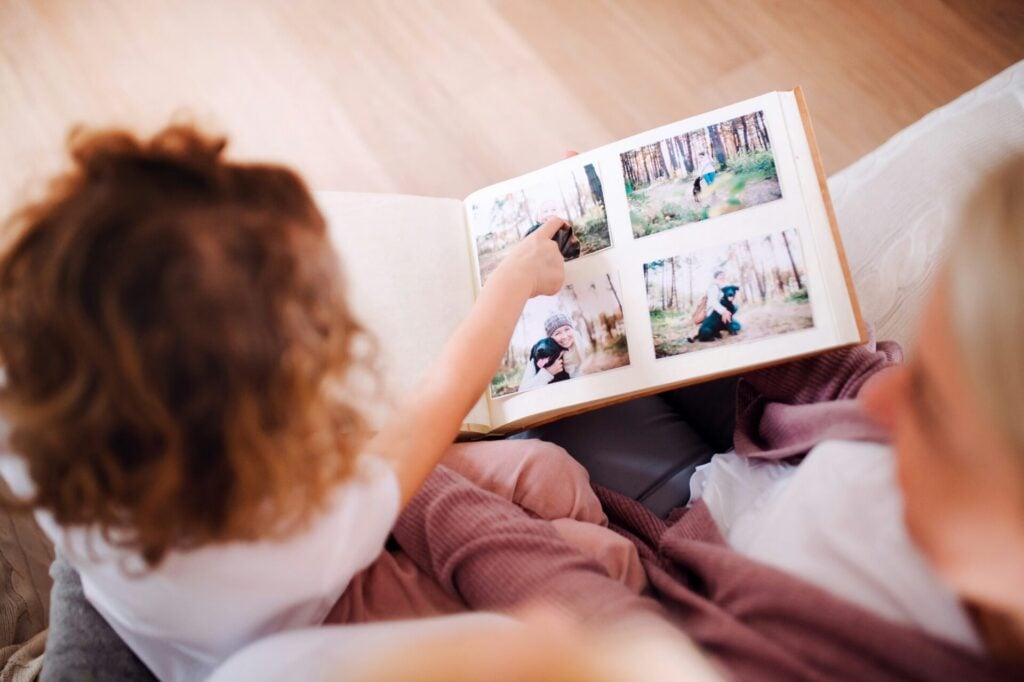 Child sharing memories from photo album