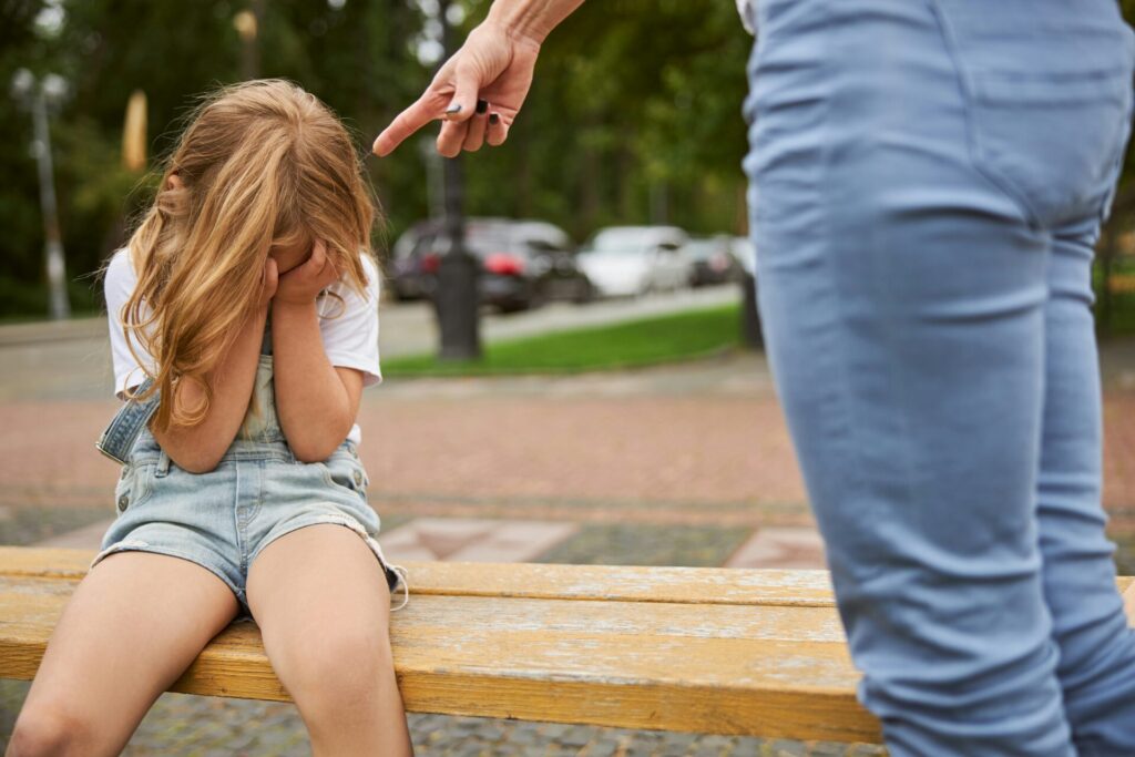 Child upset, adult scolding her.