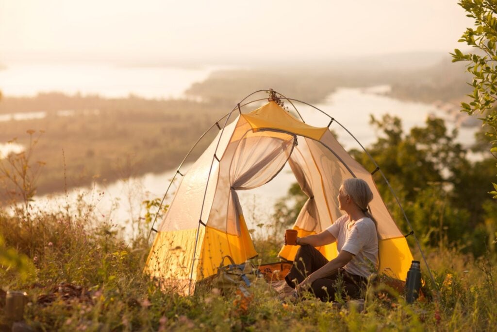Person enjoying peaceful camping experience as a conscious traveller 
