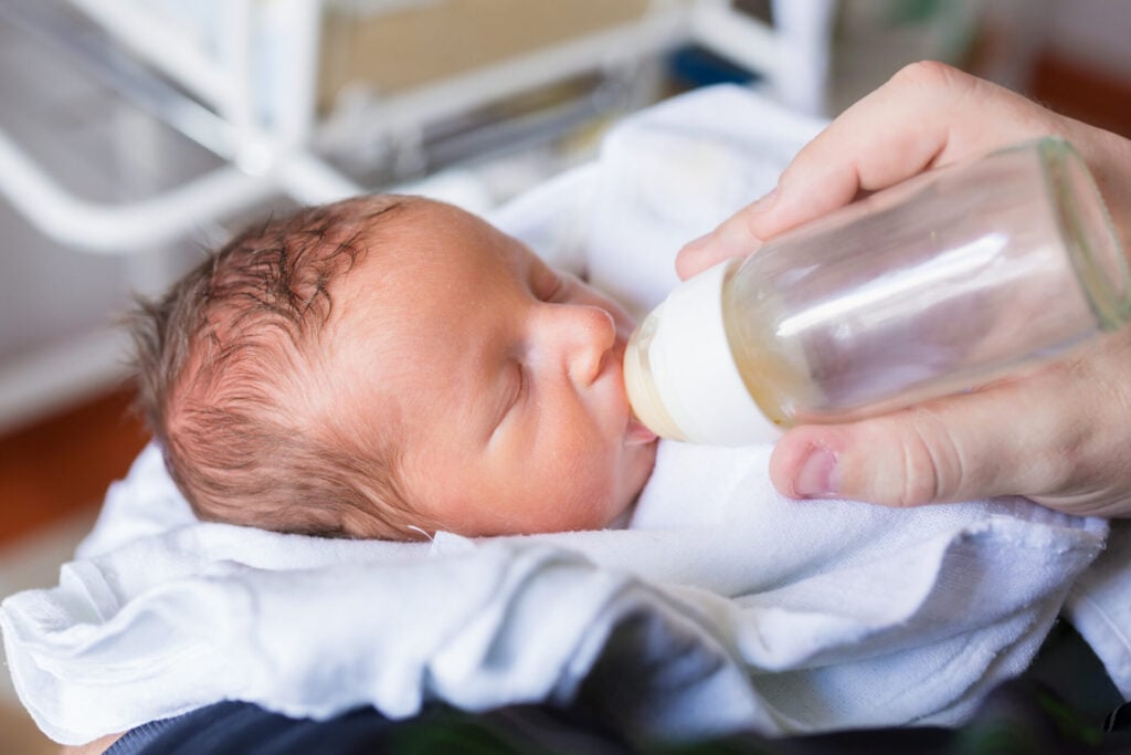small baby being fed with a milk bottle.