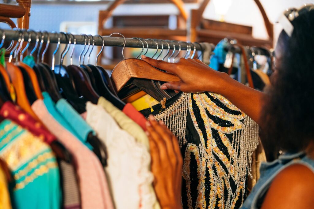 woman looking through clothes at thrift store