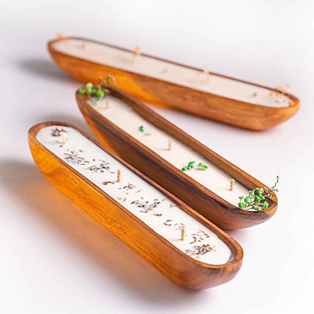 Three wooden candle holders with herbs