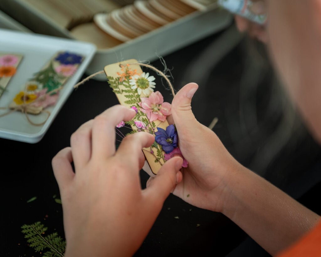girl makes bookmark at the goat festival