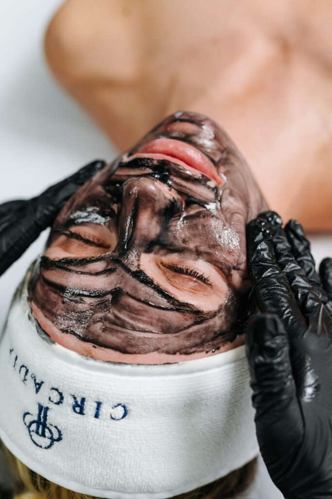 Person receiving charcoal facial treatment