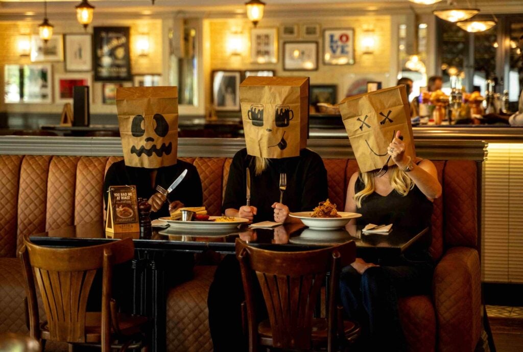 People with paper ghoul bags on heads