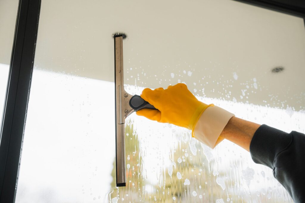 Person cleaning window with squeegee