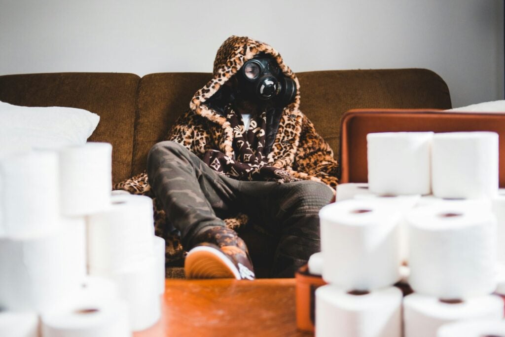 Person in gas mask surrounded by toilet paper