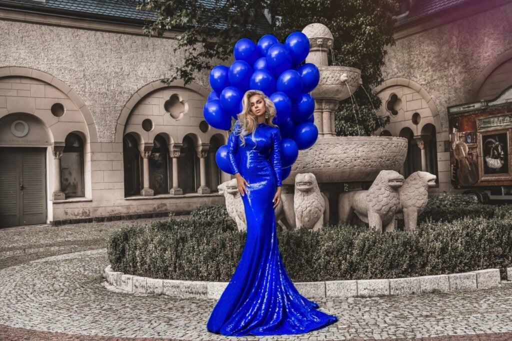 Woman in blue dress with balloons.