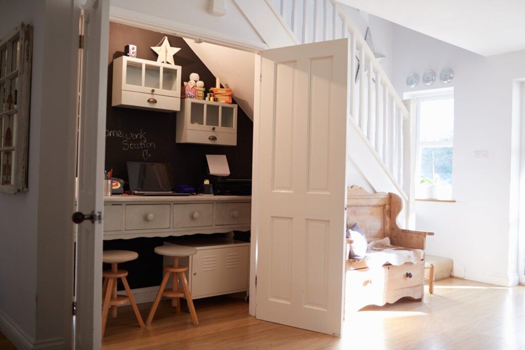 Cozy workspace under staircase with seating.