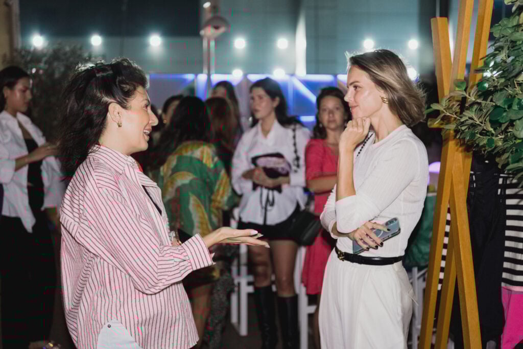 Two women engaged in conversation outdoors.