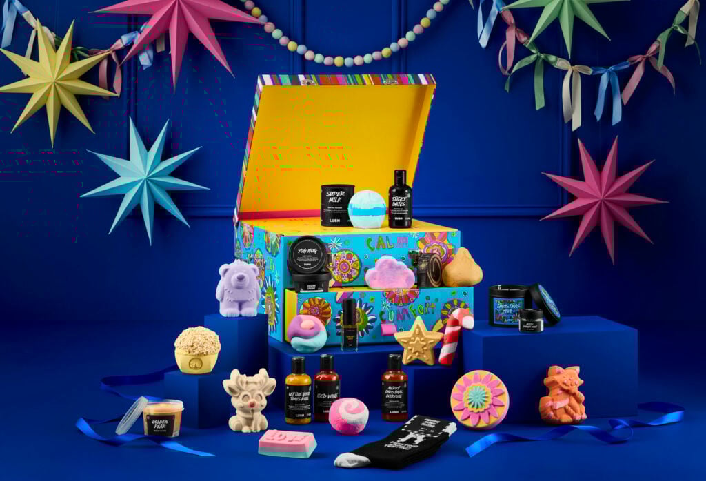The Lush advent calendar surrounded by bath bombs and naked packaging soaps