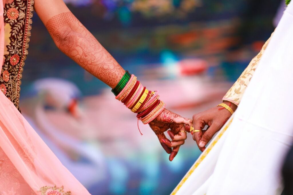 Two hands adorned with colorful bangles