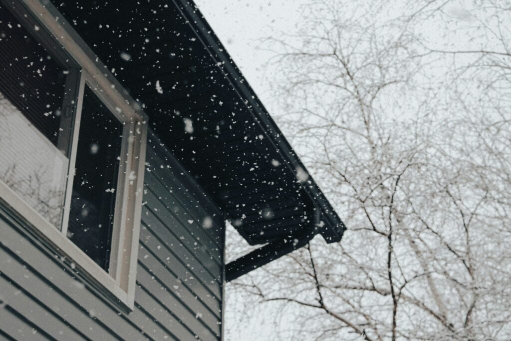 Snow falling near a house.