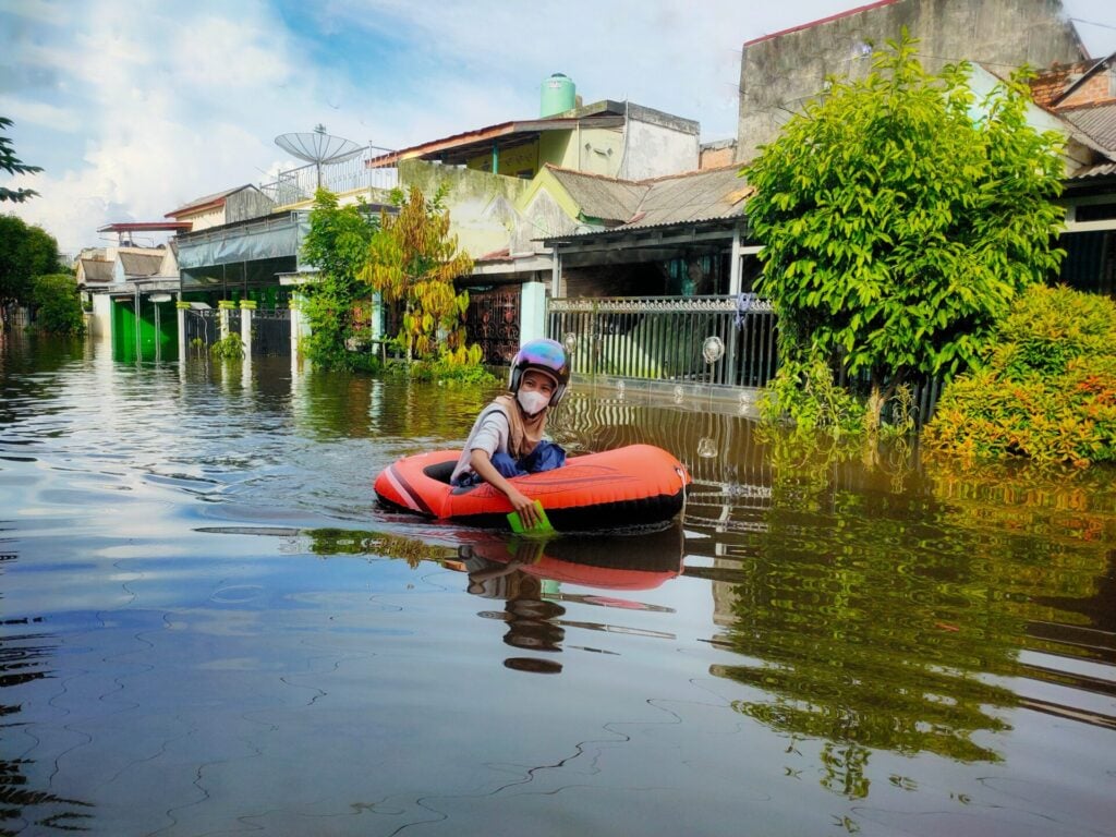 Child in inflatable boat on flood
