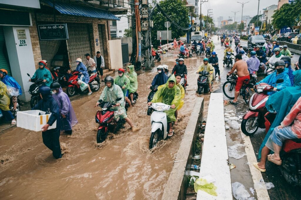 Flooded street with people and motorcycles