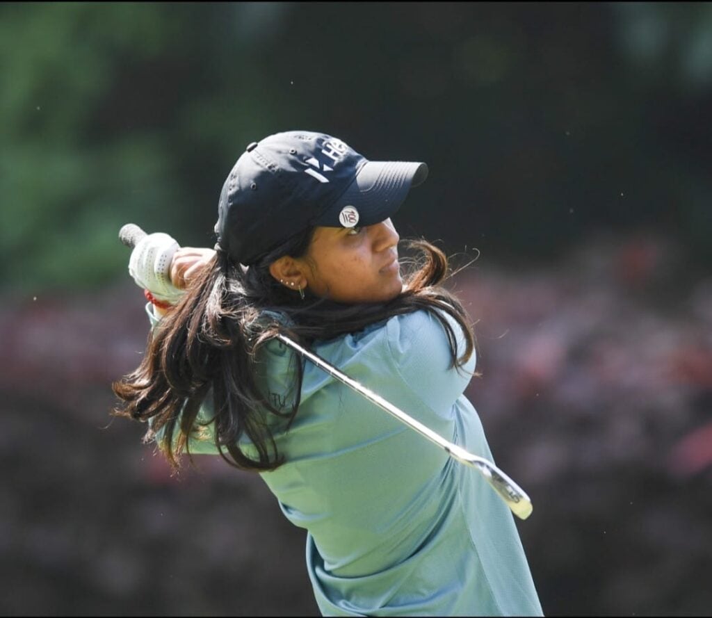 Golfer Pranavi Urs swinging club on course
