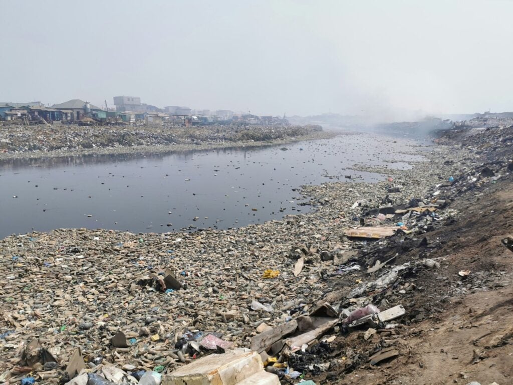 Polluted river surrounded by garbage.