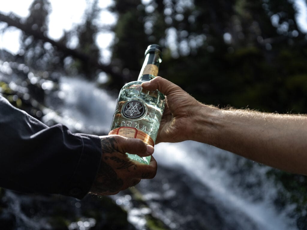two hands holding a bottle of Meili Vodka